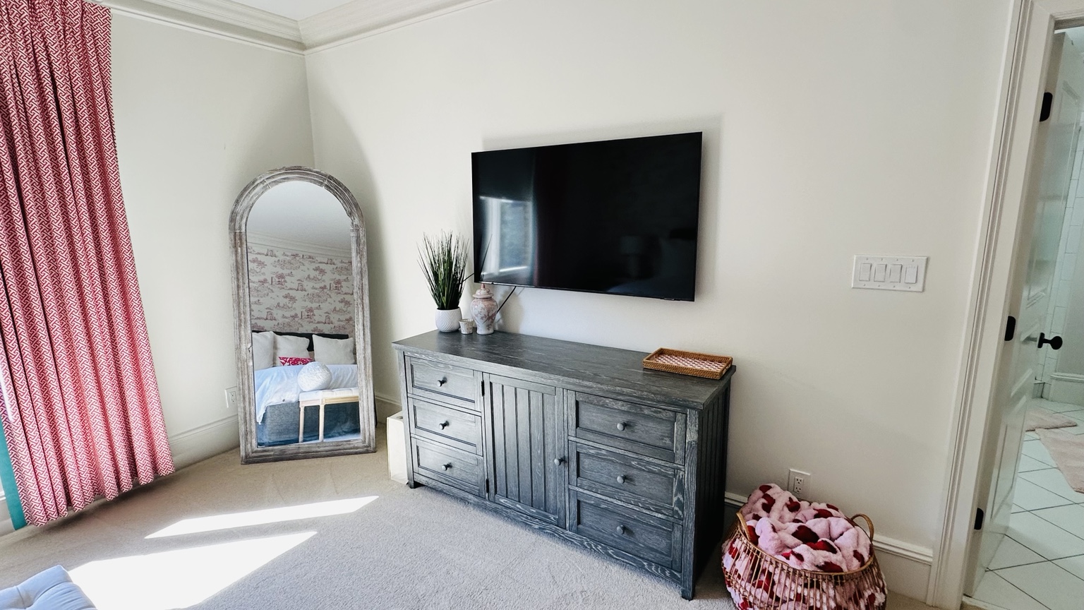 A thoughtfully finished bedroom with blush drapery and open floor space