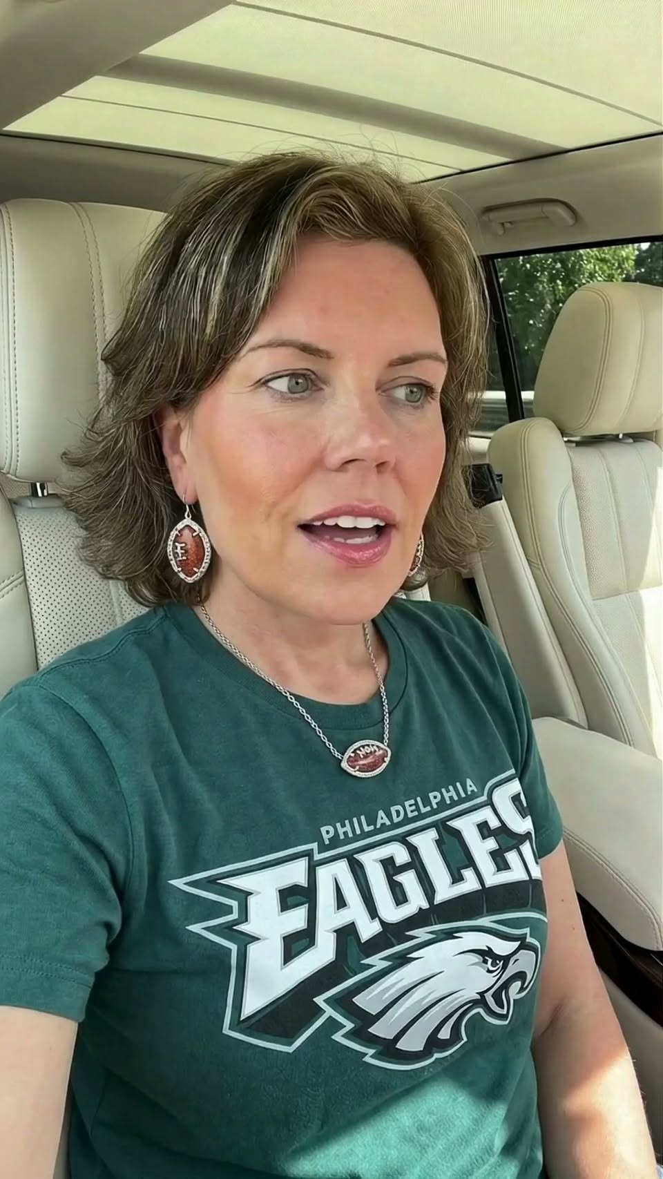Jessica wearing a Philadelphia Eagles shirt with silver football earrings and a coordinating football necklace